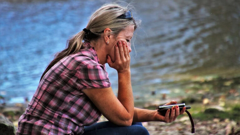 Why bother with a life coach: Woman sitting by a lake in contemplation